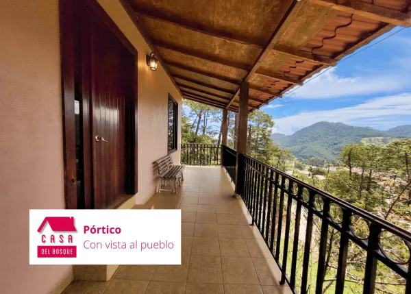 Pórtico corrido a lo largo de la cabaña, con vista al pueblo