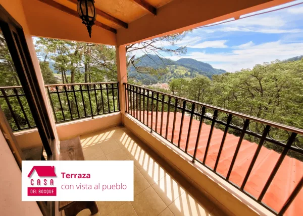 Terraza techada con barandal de herrería y vista al cerro